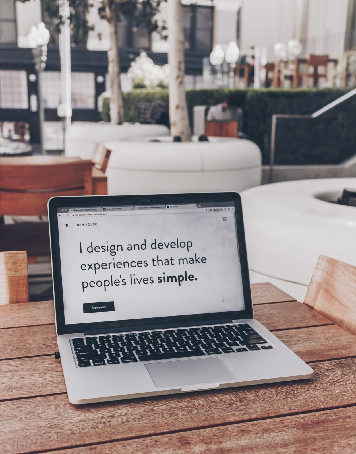 This image is of a laptop sitting on a wooden table. On the screen it reads "I design and develop experiences that make people's lives easier." This is the thumbnail for the post that talks about Technology and Accessibility.