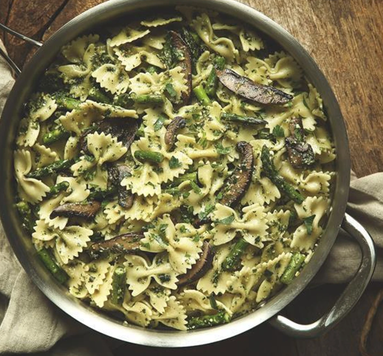 Picture of farfalle pasta with pesto sauce, asparagus, and mushrooms.