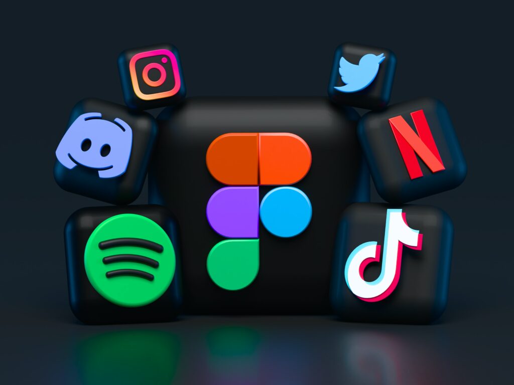 there are various social media icons hovering around a black box. On the central black box there is the colour scheme of various social media apps such as Discord, Instagram, Tiktok, Spotify, and Twitter